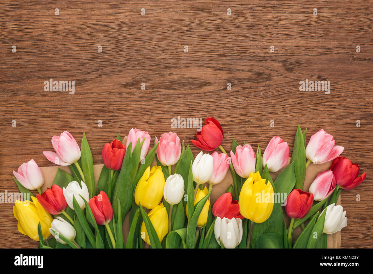 Vista dall'alto di tulipani colorati su sfondo di legno Foto Stock