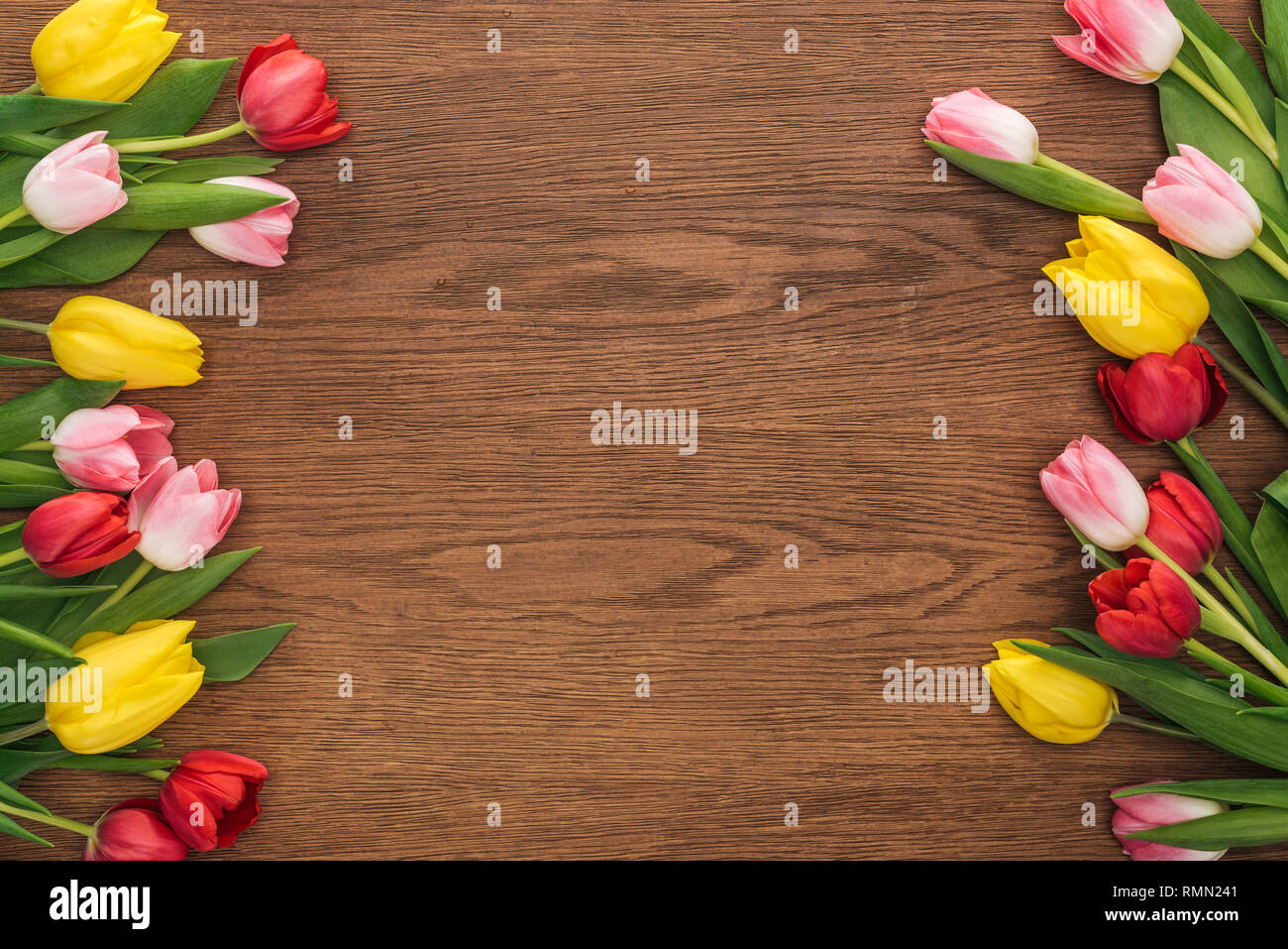 Vista dall'alto di tulipani colorati su sfondo di legno con spazio di copia Foto Stock