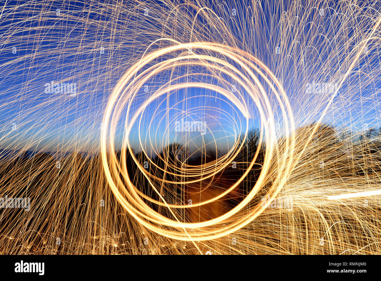 La lana di acciaio fotografia. Sentieri di luce creato da scintille durante una lunga esposizione fotografia di masterizzazione di lana di acciaio. Foto Stock