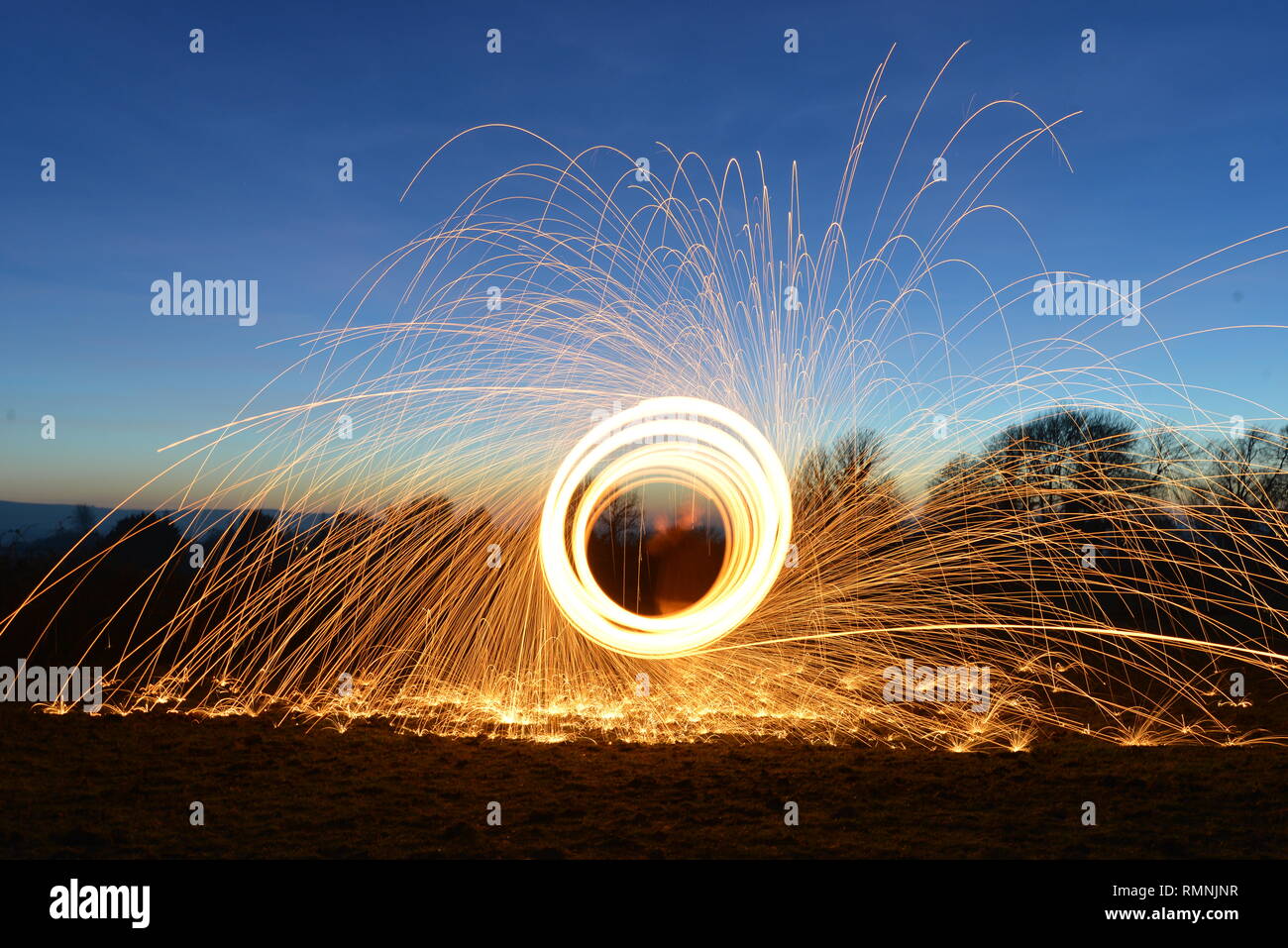 La lana di acciaio fotografia. Sentieri di luce creato da scintille durante una lunga esposizione fotografia di masterizzazione di lana di acciaio. Foto Stock
