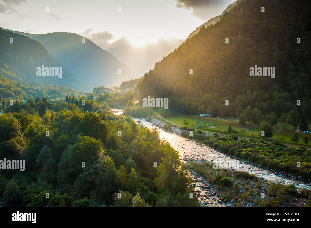 Il Sesia River Valley, con raggi solari che filtrano attraverso le nubi a ora d'oro. Scopello, Piemonte, Italia settentrionale. Foto Stock