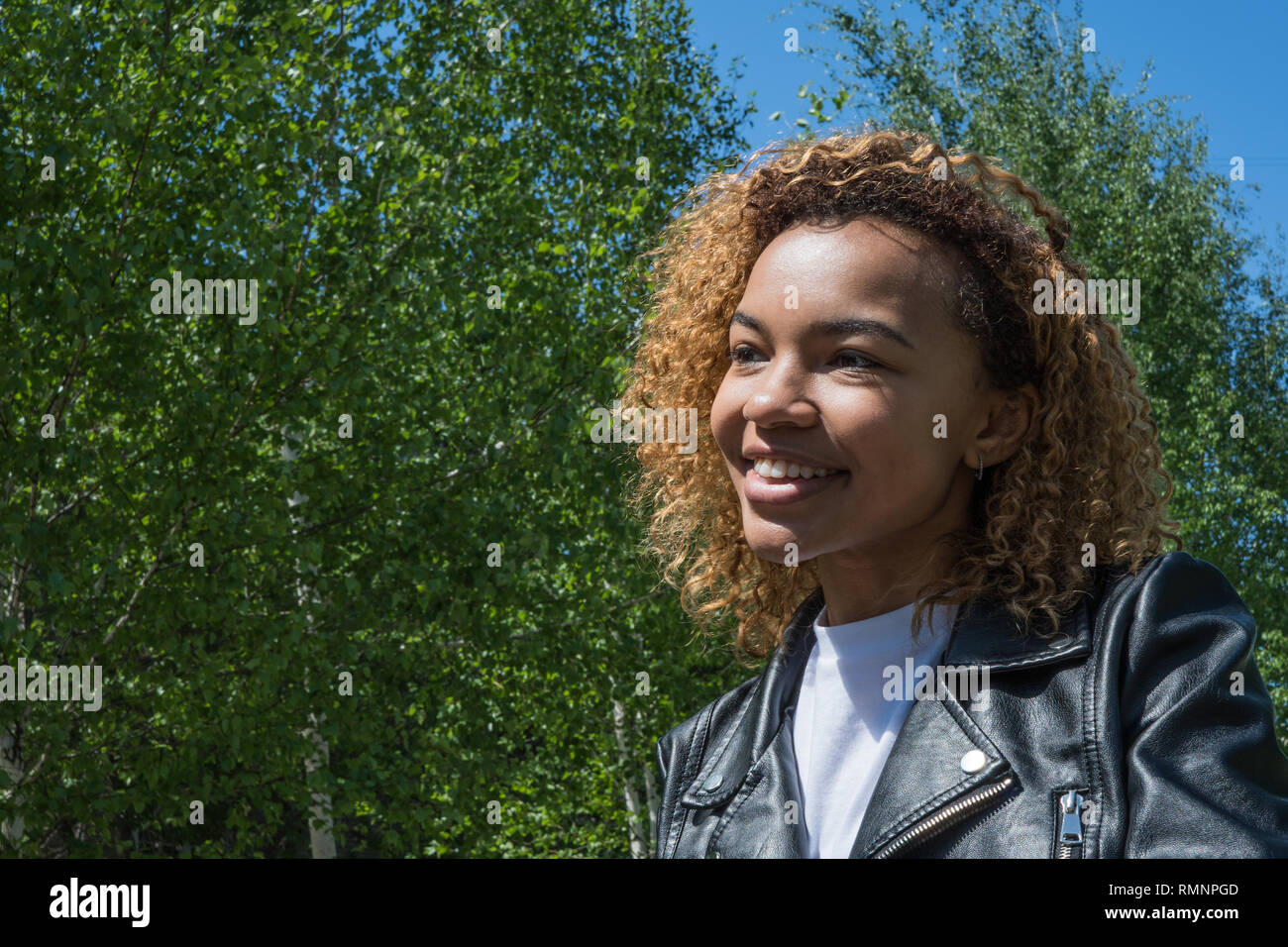 Bella ragazza africana modello in posa profilo a molla sulla strada Foto Stock