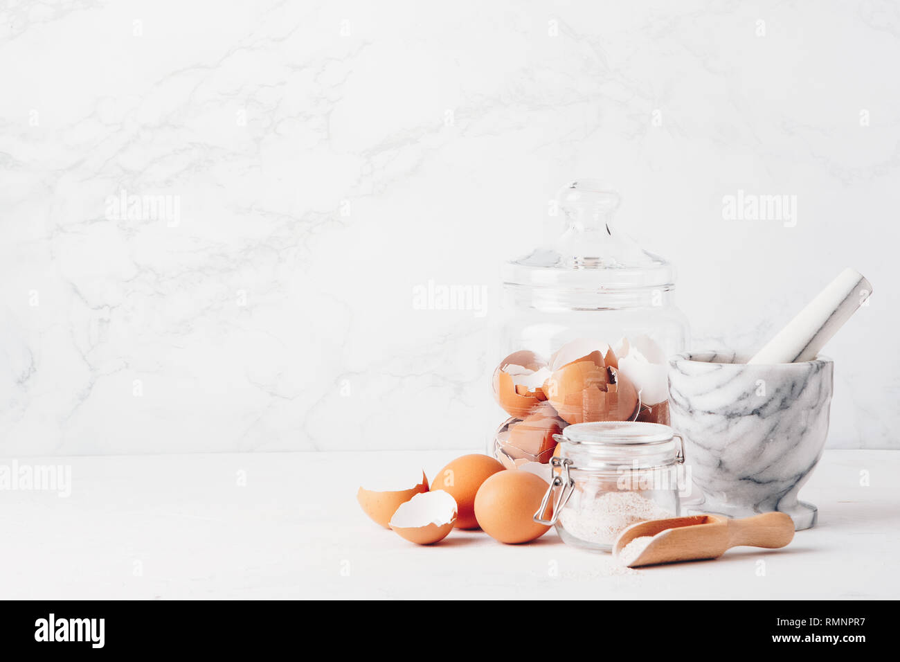 Massa a guscio di uovo, in casa di calcio. Mortaio in marmo, uova, conchiglie, calcio Foto Stock