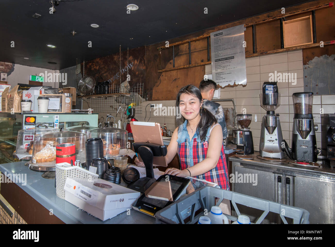 Due persone che lavorano in una caffetteria nel sobborgo di Sydney di Maroubra in Australia Foto Stock