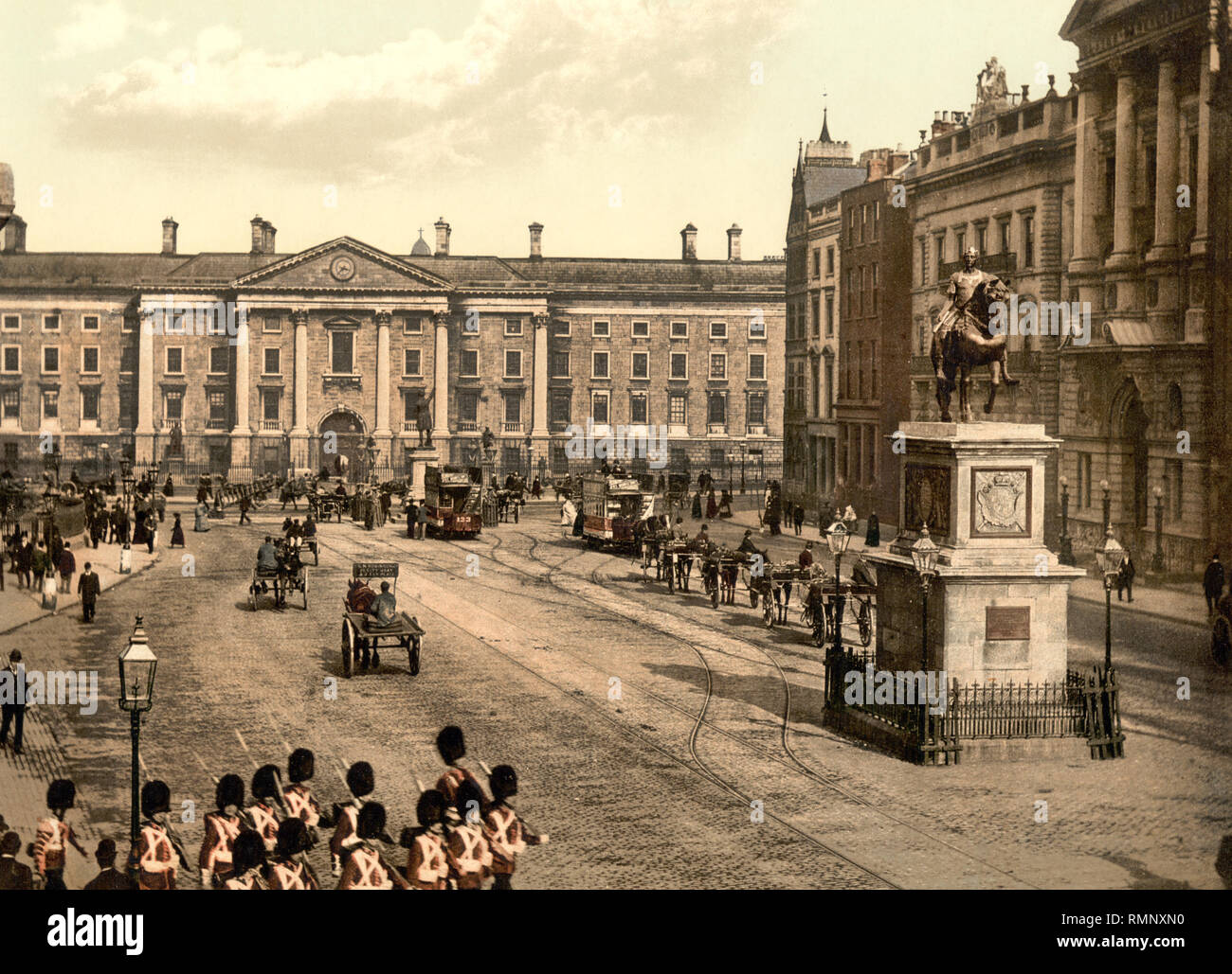 Photomechanical print di College green Dublino circa 1900 con British redcoat truppe, Trinity college e la statua del re Guglielmo III Foto Stock