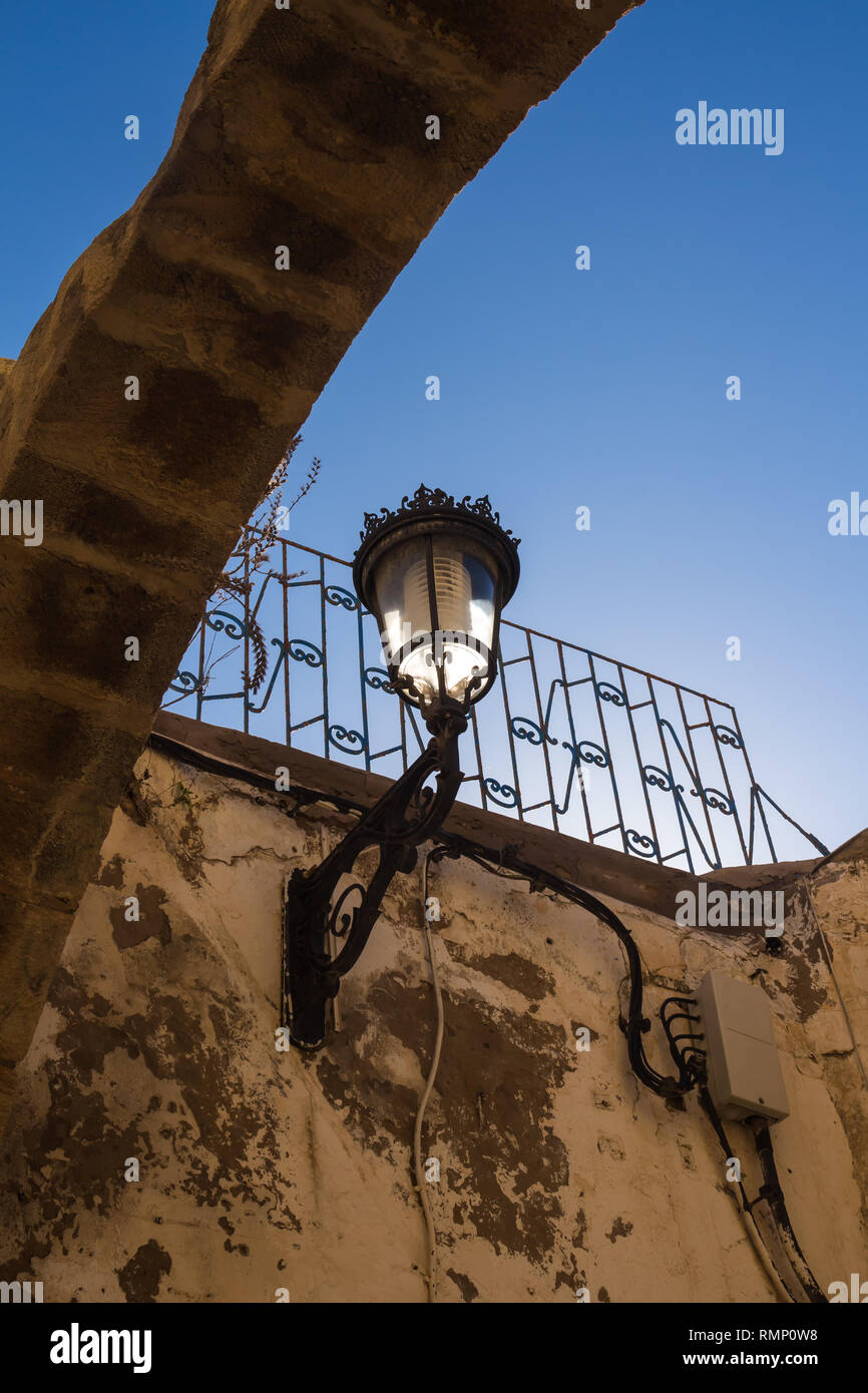 La forma classica di un lampione - lanterna, come un patrimonio europeo su un edificio di Safi, Marocco. Illuminata dal sole del mattino. Azzurro cielo. Foto Stock