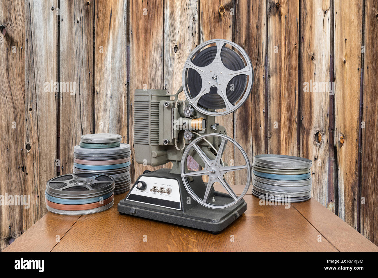 Vintage 8mm home proiettore video e film lattine con il legno vecchio muro. Foto Stock