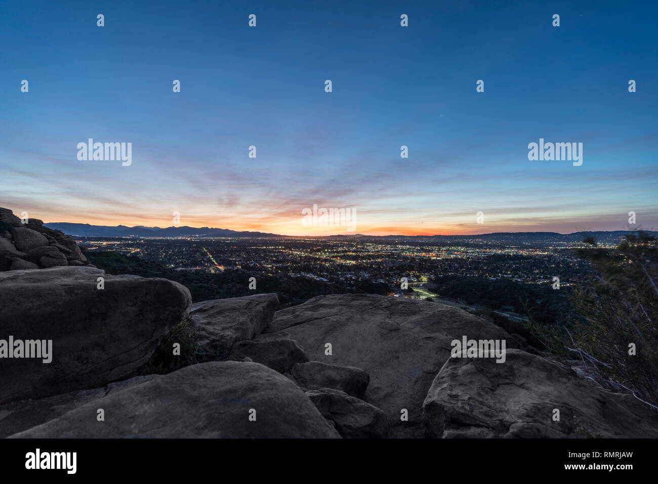 Collina rocciosa predawn vista della valle di San Fernando quartieri e le montagne di San Gabriel nella città di Los Angeles, California. Foto Stock