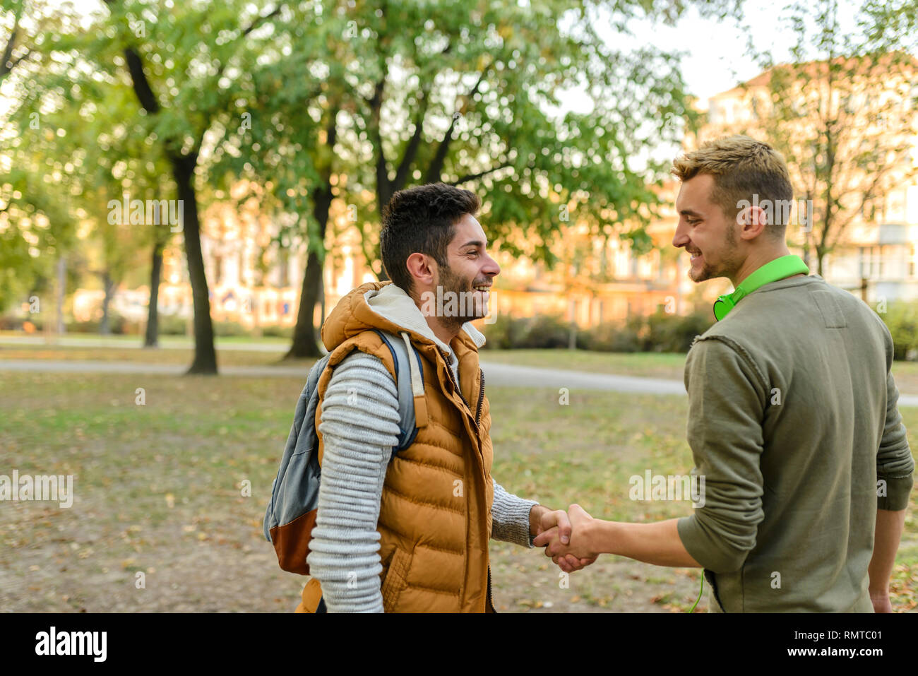 Due ragazzi belli stringono le mani dopo aver visto ogni altro dopo il lungo periodo di tempo Foto Stock