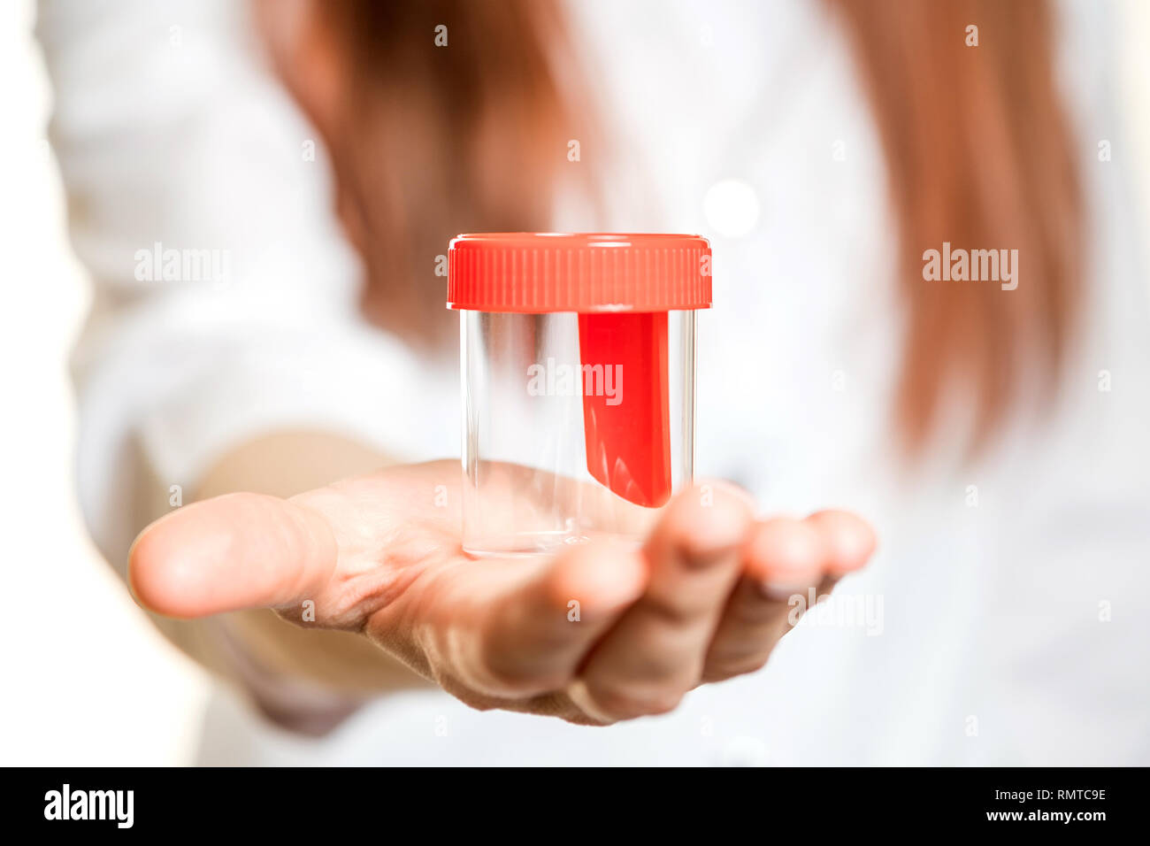 Mano che tiene il tubo di prova su sfondo bianco Foto Stock