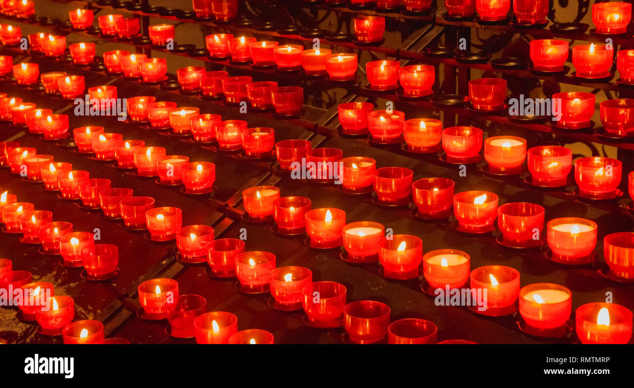 Un sacco di rosso la Pasqua candele accese in chirch Foto Stock