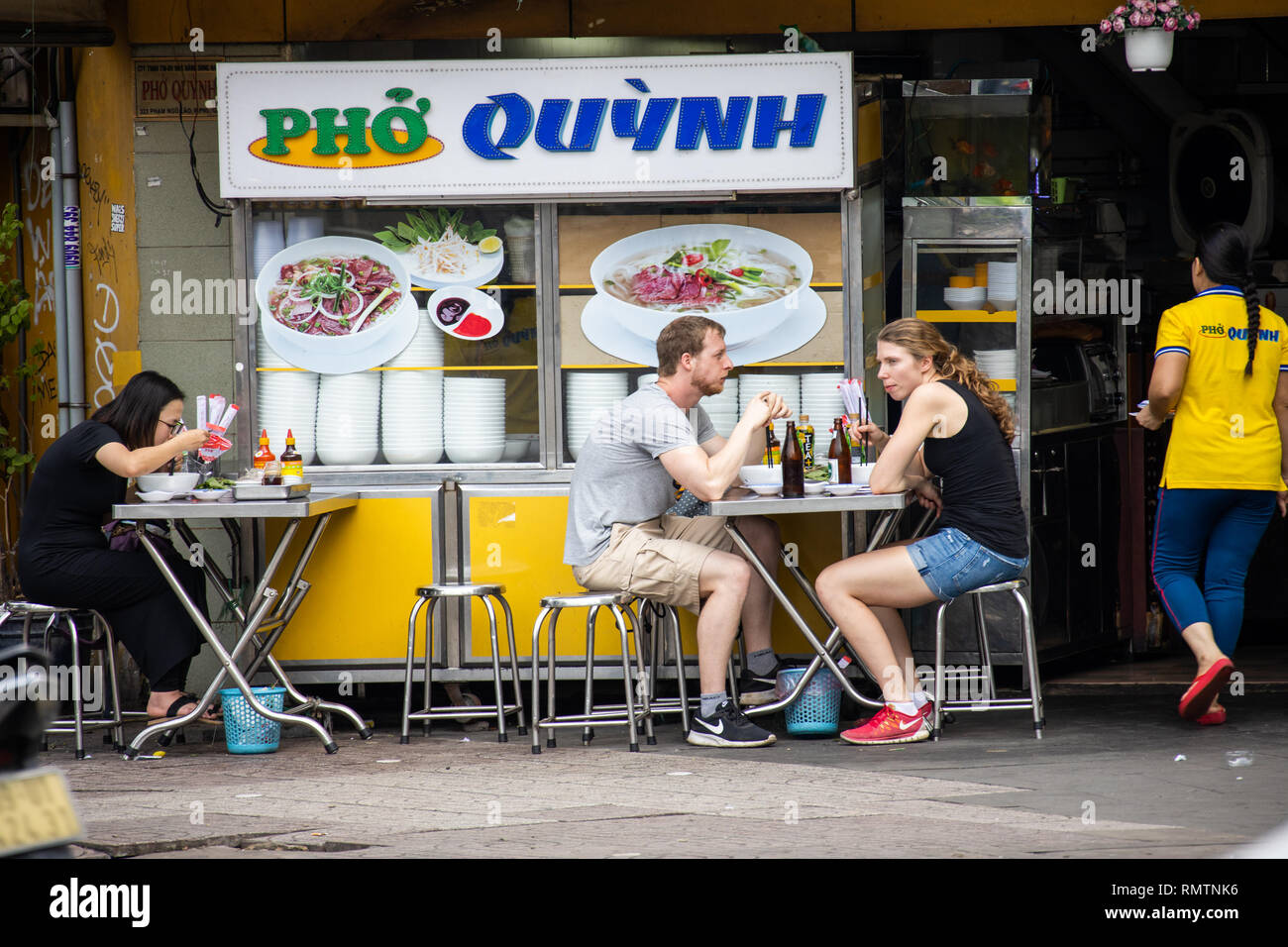 I turisti a mangiare Pho Quynh, un popolare ristorante nella città di Ho Chi Minh, Vietnam Foto Stock