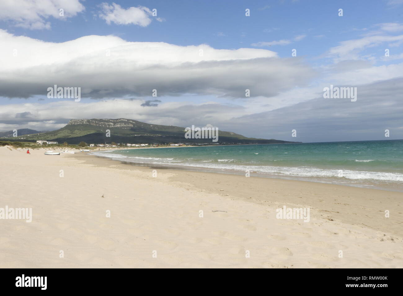 Weißer Sand-Strand wolkig mit Bergen und Meer Foto Stock