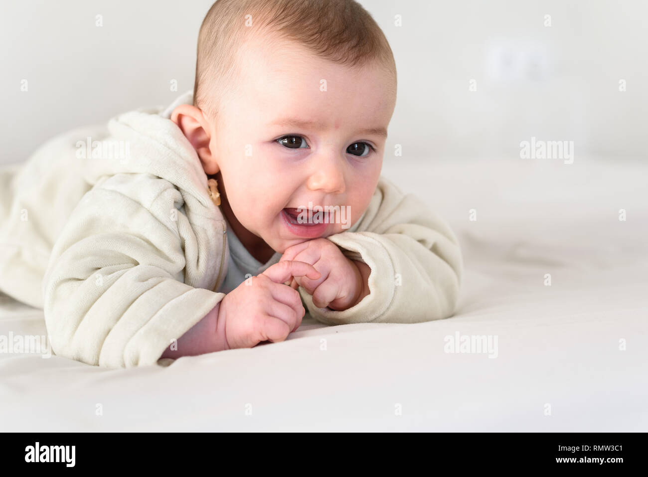 Ritratto di un adorabile sorridente bambino tiene testa in alto, vestito in pigiama. Foto Stock
