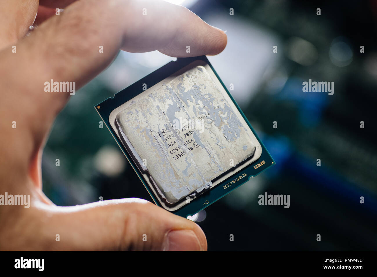 London, Regno Unito - 5 Febbraio, 2019: Man mano che l'ingegnere azienda tecnologica contro lo sfondo della scheda madre nuovi processori Intel Xeon professional processore CPU Broadwell FCLGA2011-3 Foto Stock