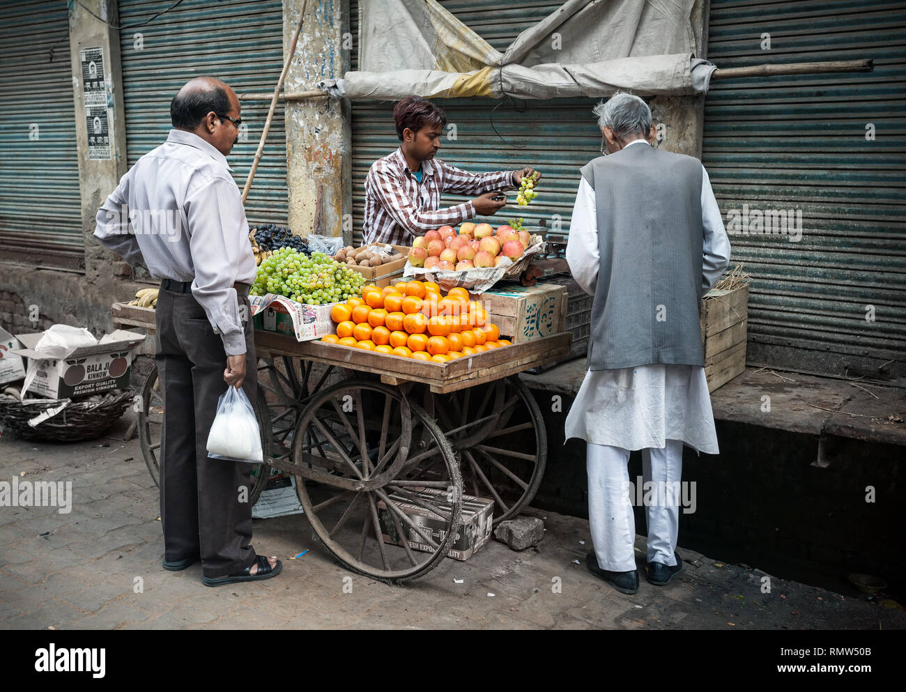 AGRA, Uttar Pradesh, India - Febbraio 24, 2015: uomo musulmano acquisto di frutti dal venditore sul Taj Ganj Street Foto Stock