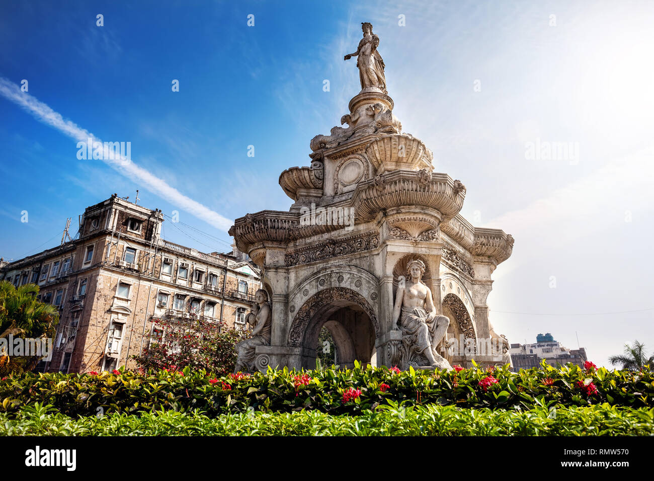 Fontana della flora orientali e antico edificio nel cielo blu nella soleggiata a fort area in Mumbai, Maharashtra, India Foto Stock
