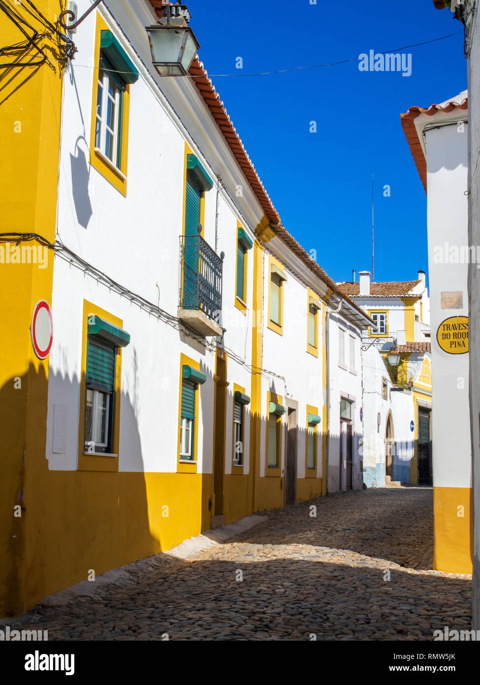 Vecchio giallo e case bianche in Evora, un epoca romana la città e capitale della provincia di Alentejo, Portogallo. Foto Stock