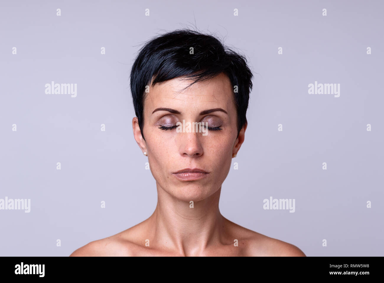 Ritratto frontale di una donna in breve capelli scuri con gli occhi chiusi Foto Stock