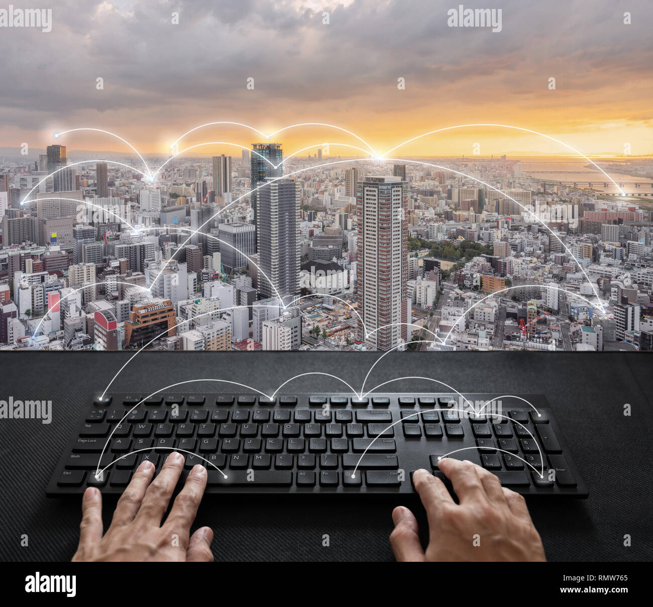 La rete Internet e il collegamento, mano digitando tastiera digitale e la città di Alba Foto Stock