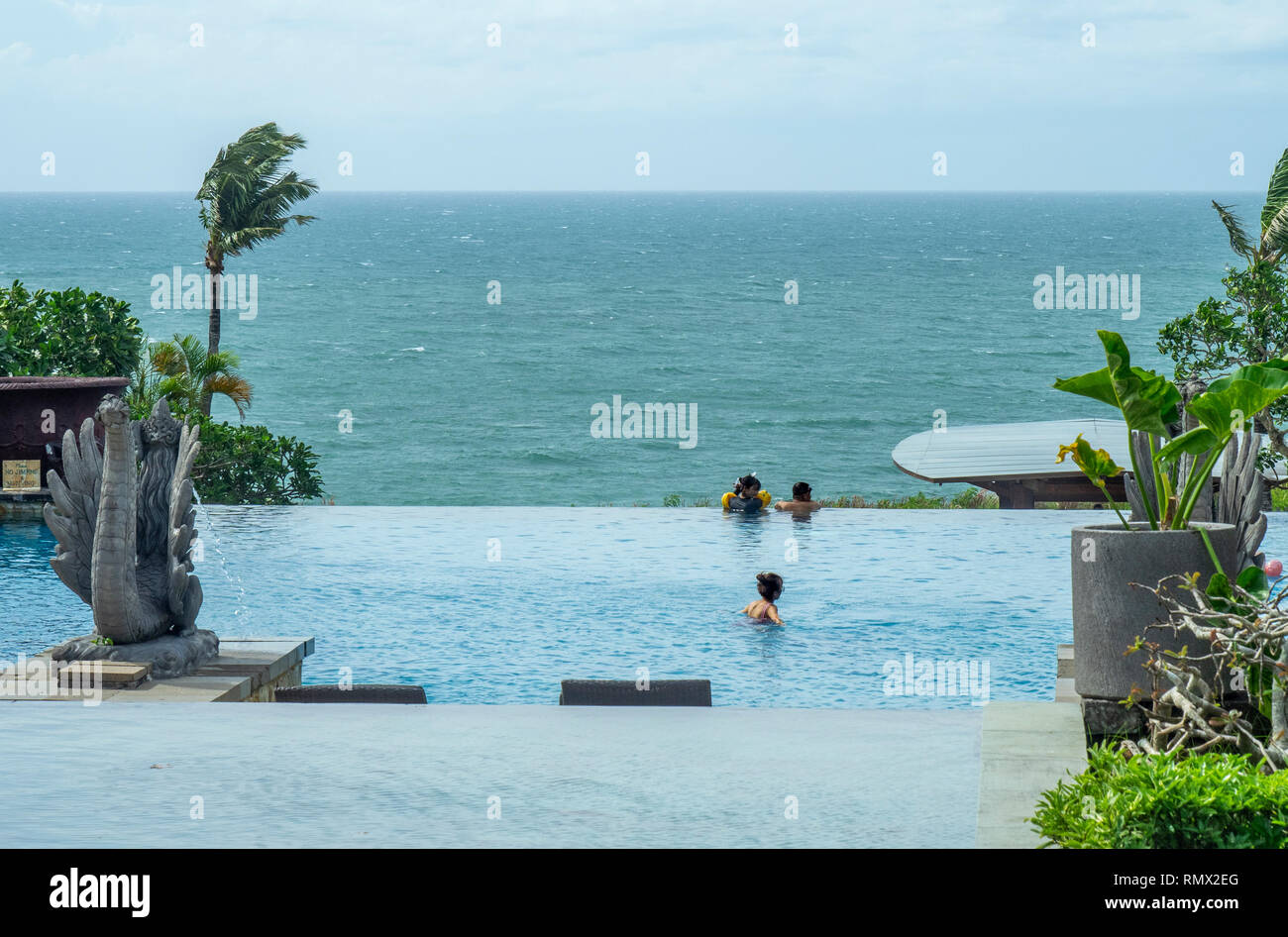 Tre persone in una piscina infinity in L'Ayana Resort and Spa Bali Jimbaran Indonesia. Foto Stock