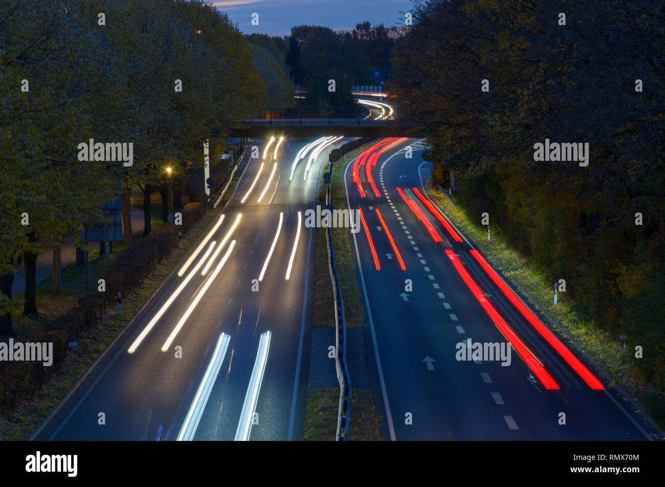 Circolazione su una superstrada di notte in una lunga esposizione con percorsi di luce dei fari e delle luci di coda volger via nella distanza visto fro Foto Stock