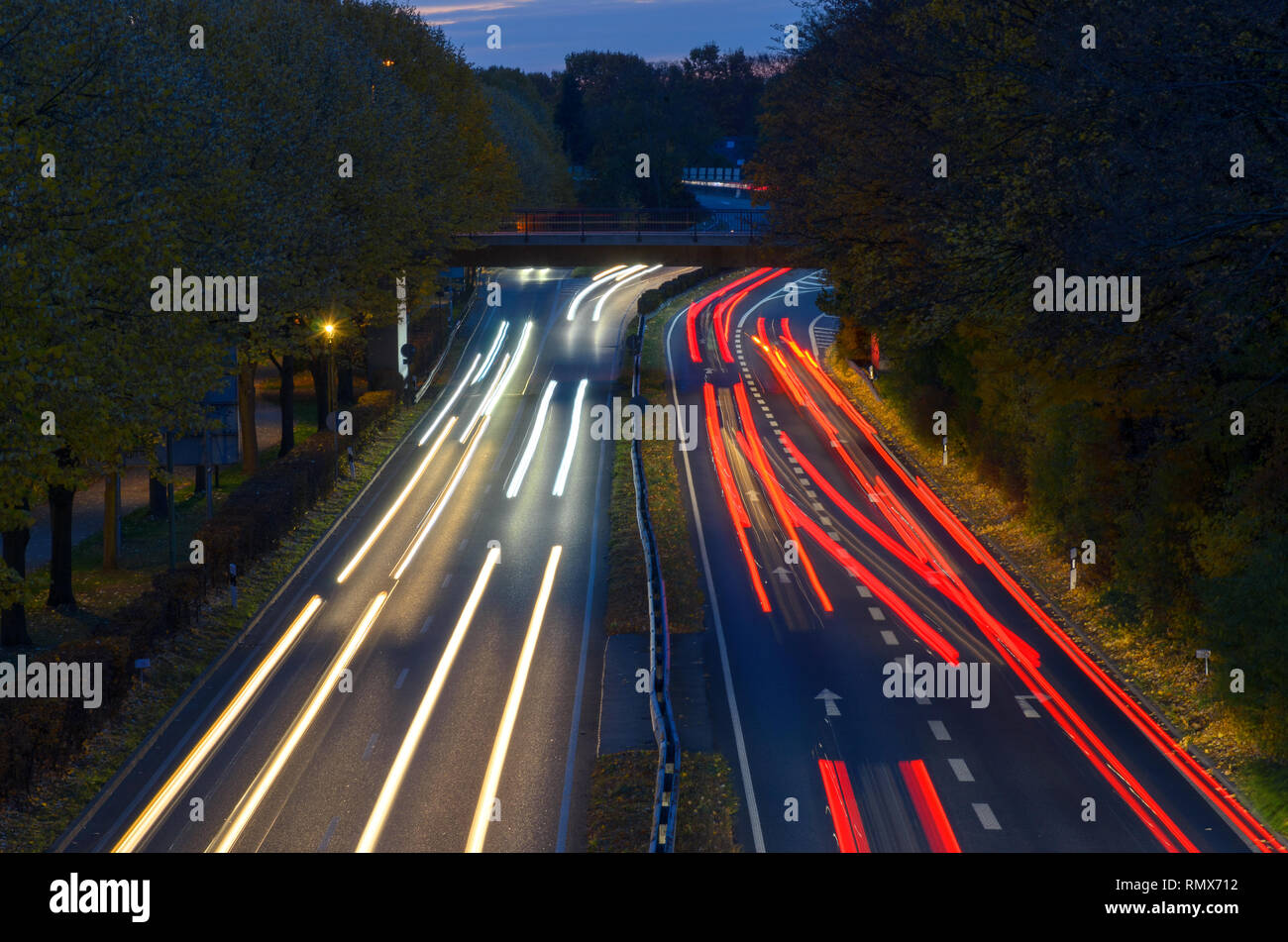 Circolazione su una superstrada di notte in una lunga esposizione con percorsi di luce dei fari e delle luci di coda volger via nella distanza visto fro Foto Stock