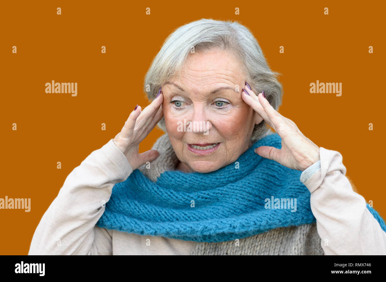 Confusi e disorientati senior lady tenendo le sue mani per i suoi templi come si guarda a parte, concettuale di insorgenza di demenza o morbo di Alzheimer Foto Stock