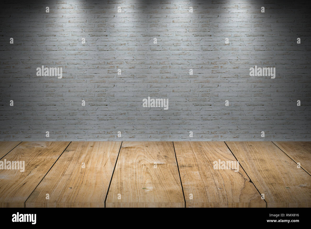 Bianco parete in mattoni con tavolo in legno per lo sfondo. Foto Stock