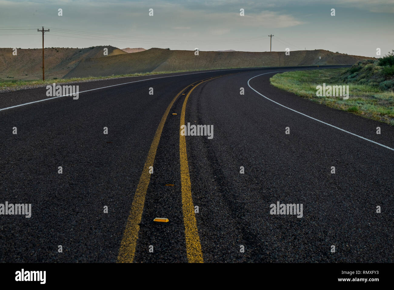 Strada curva asfalto con doppia linea gialla ad ovest del Texas. Foto Stock