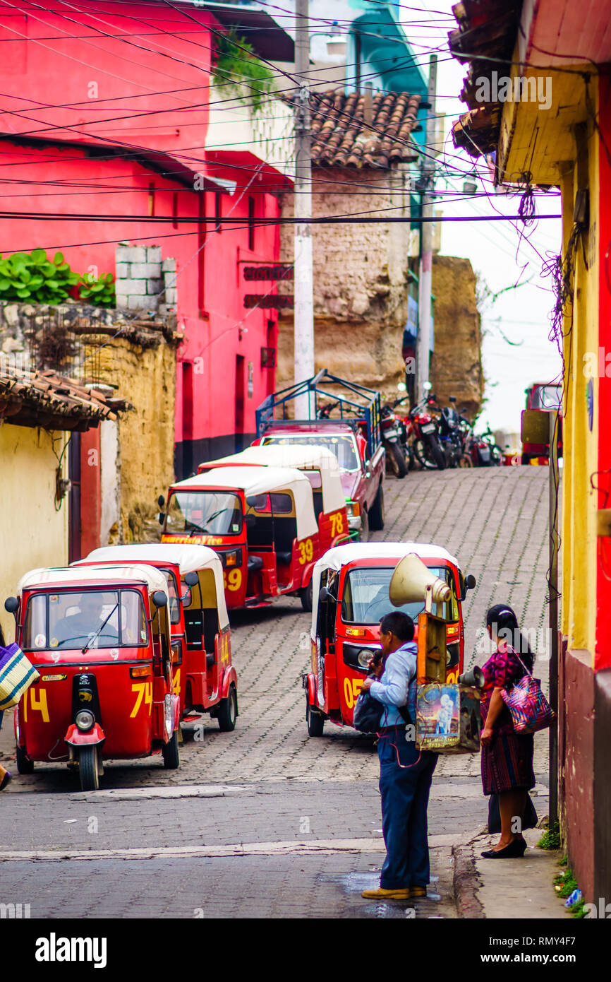 Chichicastenango, Guatemala il 02 Maggio 2016: vista sulla persona indigena informare le persone con louspeaker in una strada piena di tuk tuk Foto Stock
