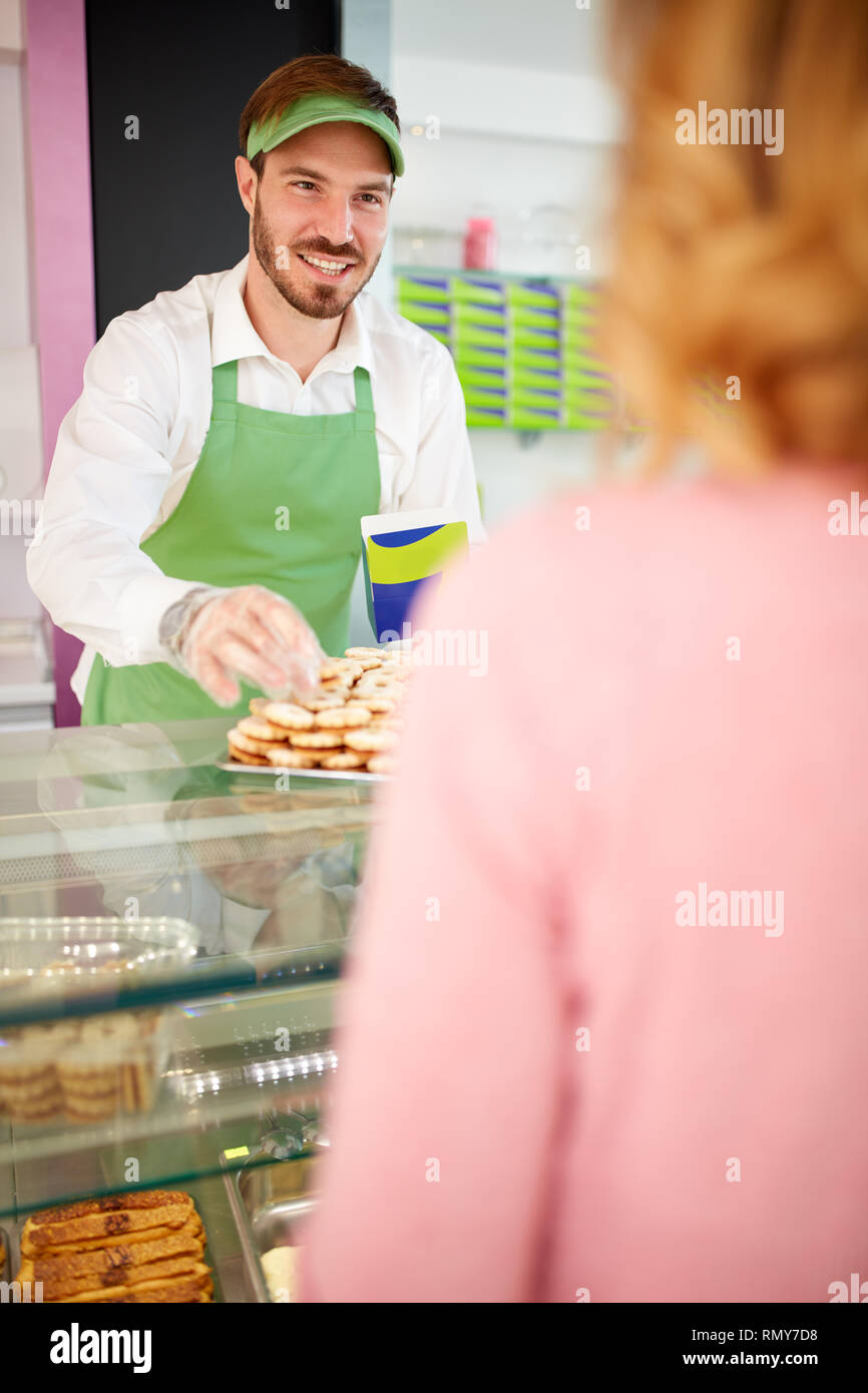Salersman sorridente e costumista picking i cookie Foto Stock