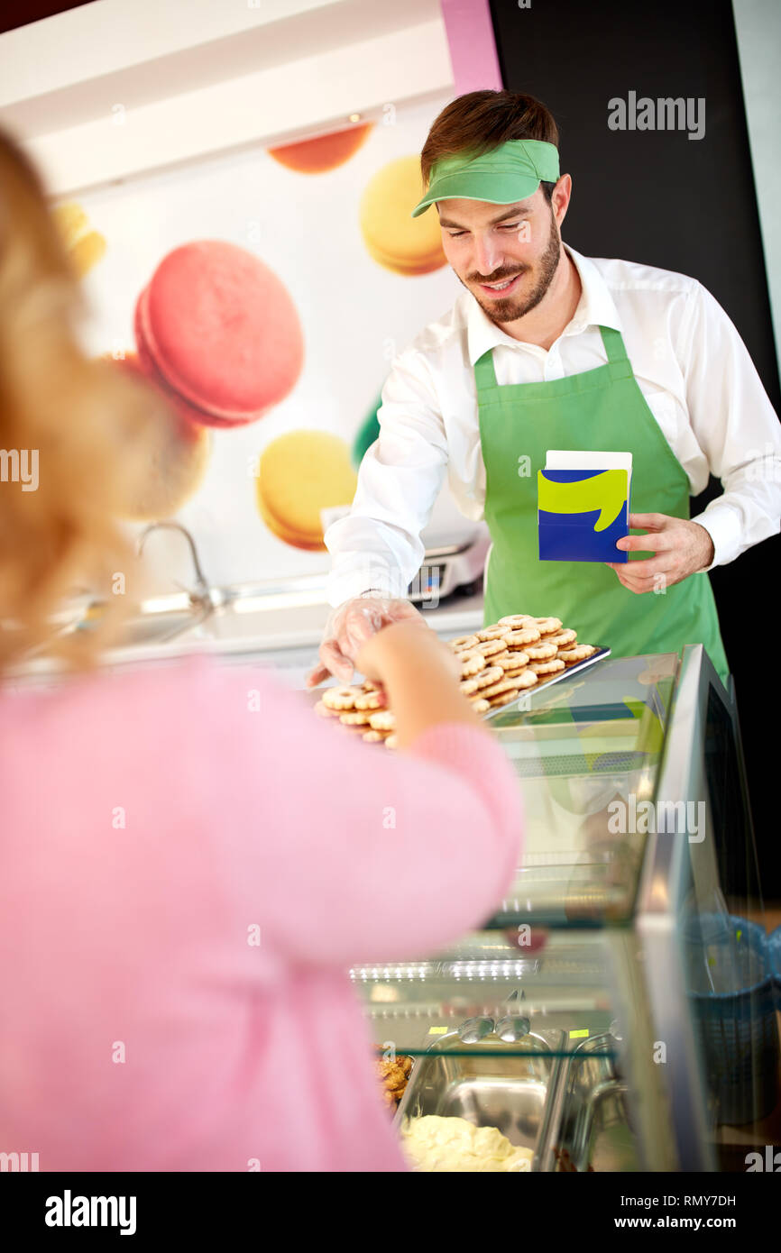 Venditore di dolciumi che mostra i cookie di Nizza sulla piastra Foto Stock