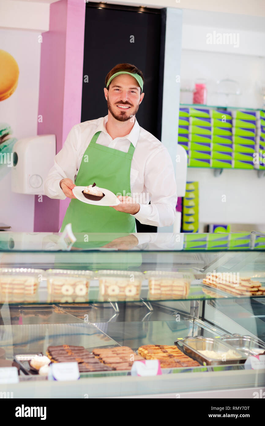 Pasticceria venditore mostra bella tortina su piastra Foto Stock