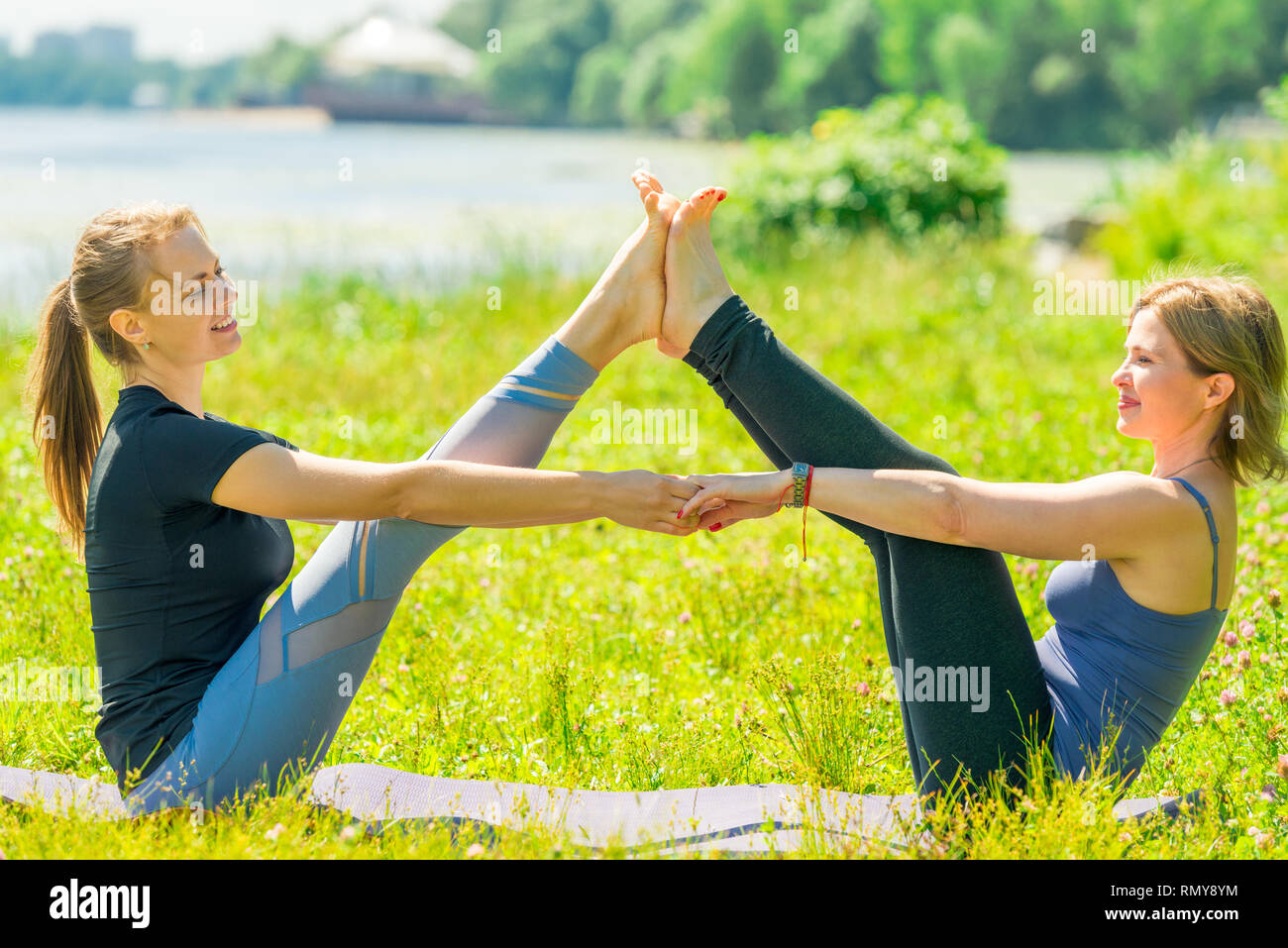 Donna matura fare yoga esercizi di stretching con un trainer individuale nel parco Foto Stock
