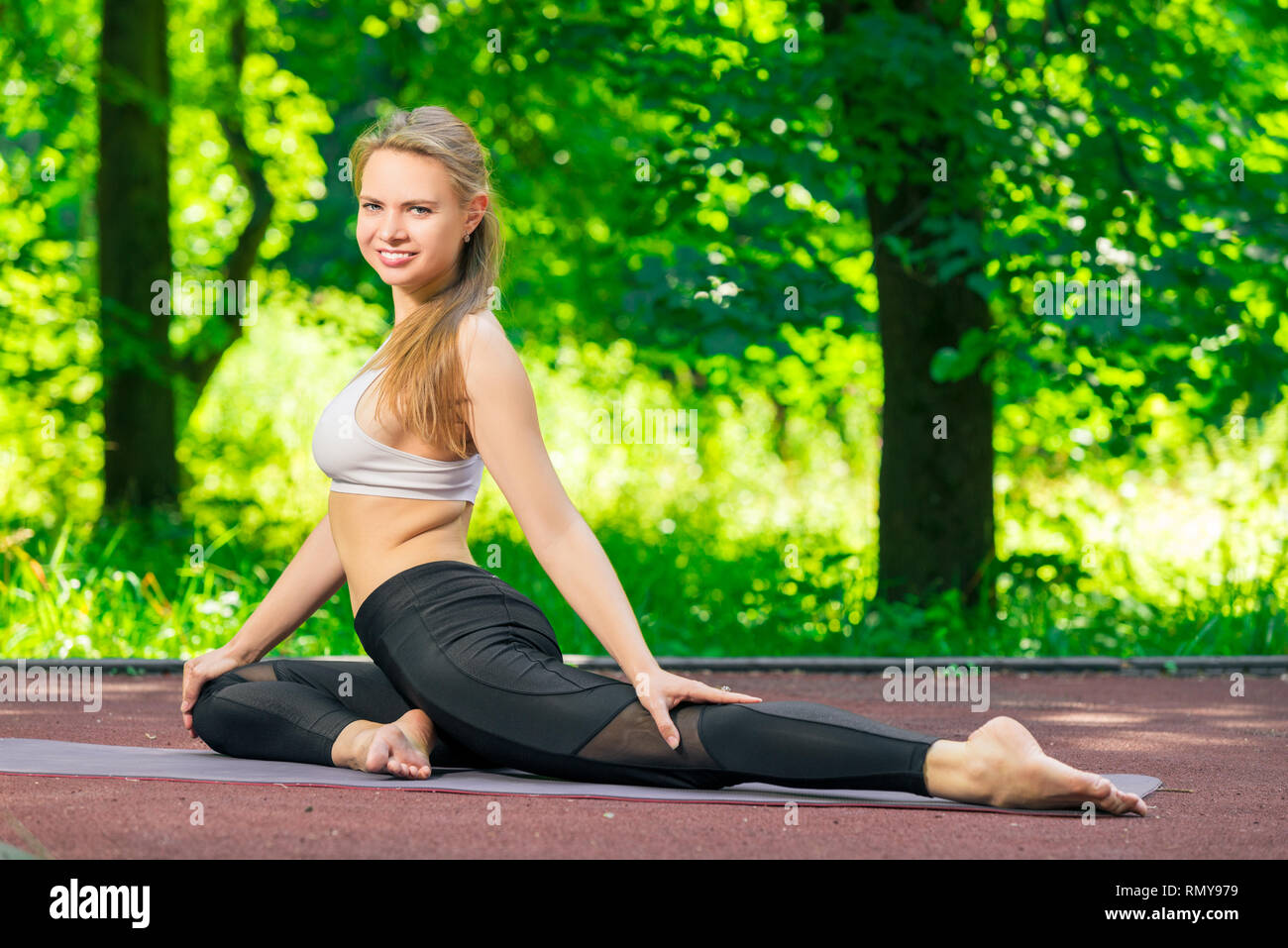 Bella donna durante un allenamento di pilates, uno stile di vita sano nel parco Foto Stock