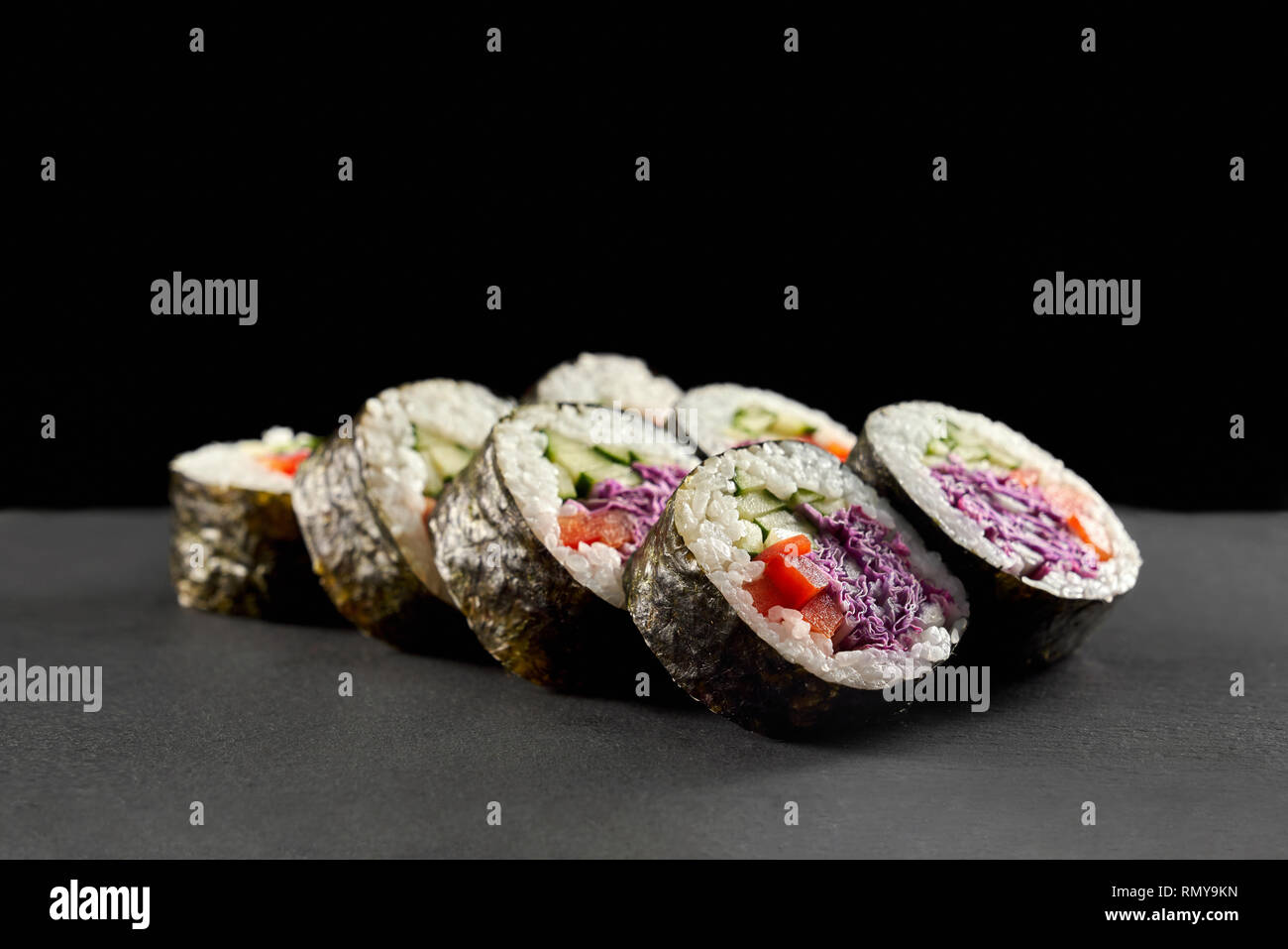 Veggie maki con riso in bianco, il cetriolo, la paprica rossa e viola il cavolo. Menu Sushi per vegetariani. Panini freschi con ripieno di verdure. Foto Stock