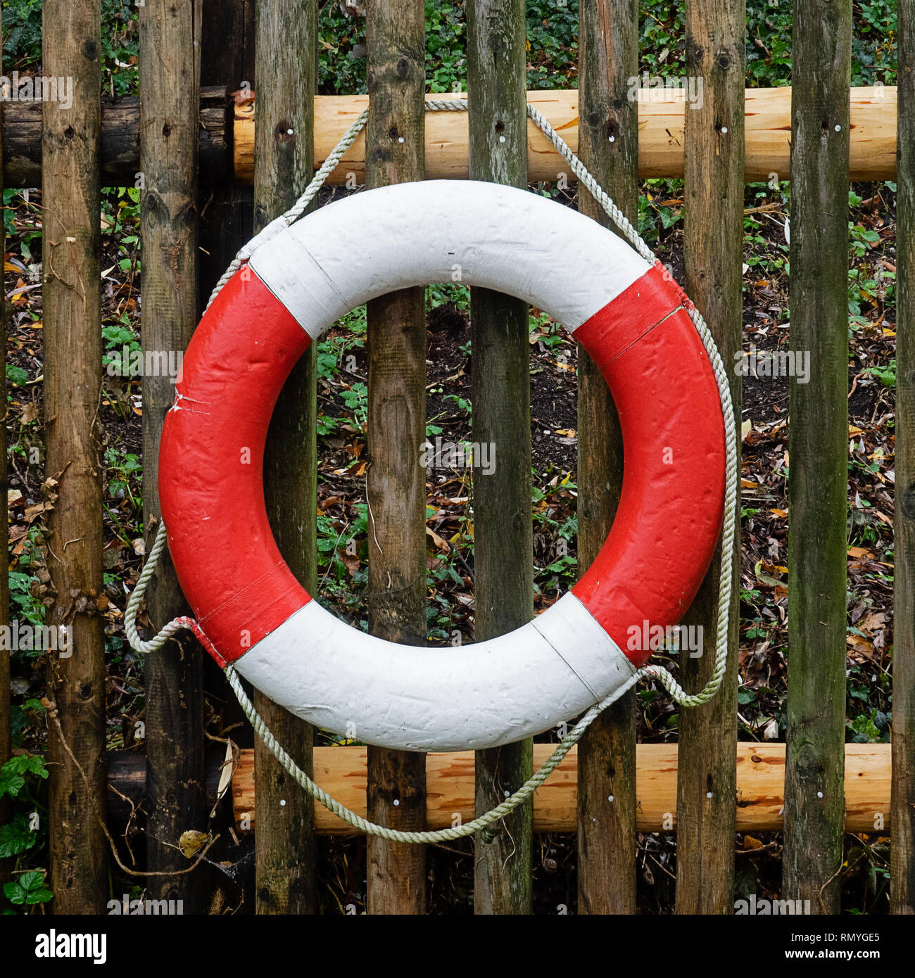 Rosso e bianco anello di salvataggio appesa su una recinzione Foto Stock