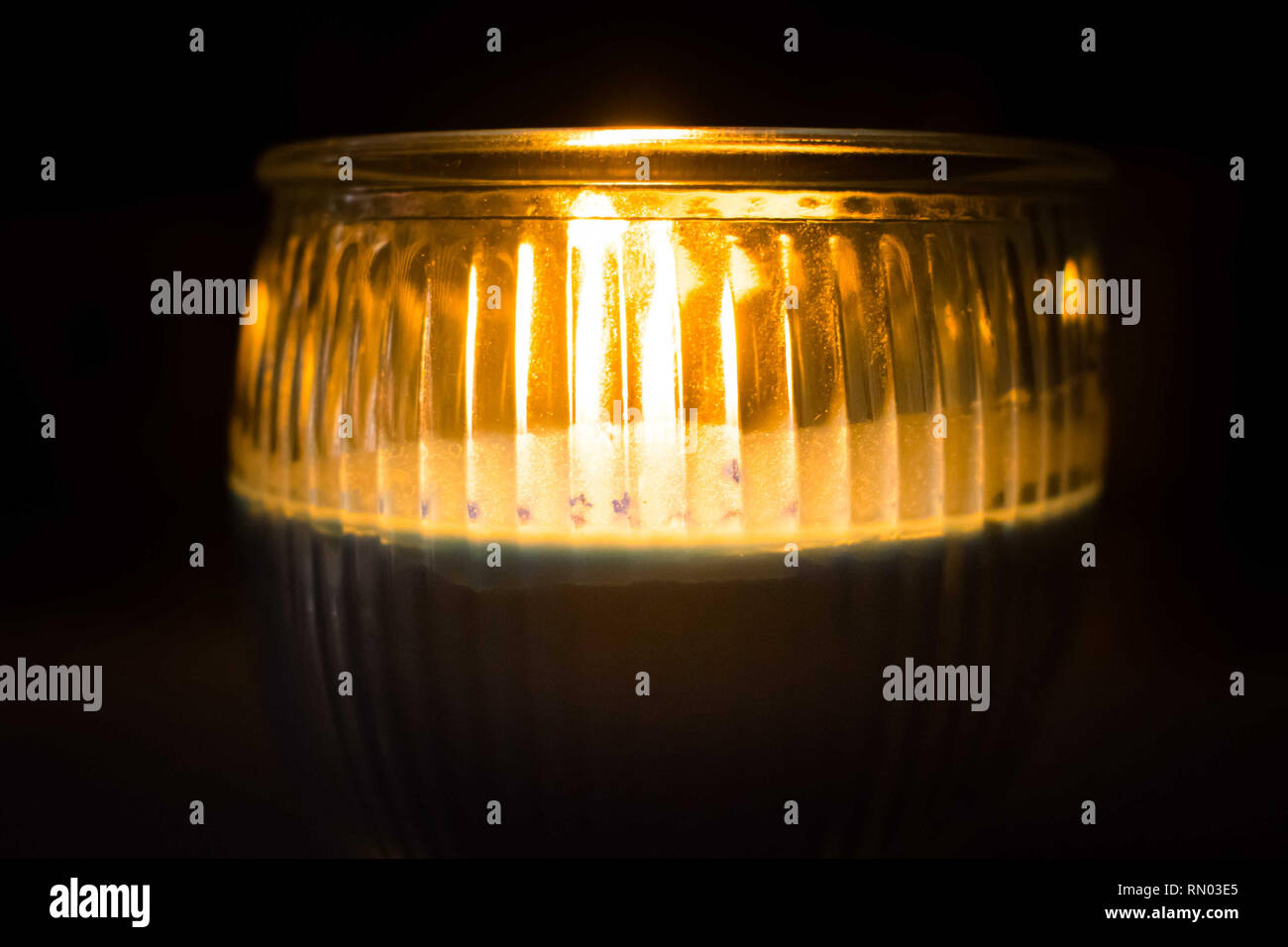 La luce di una candela su un vasetto, illuminate, candela profumata Foto Stock