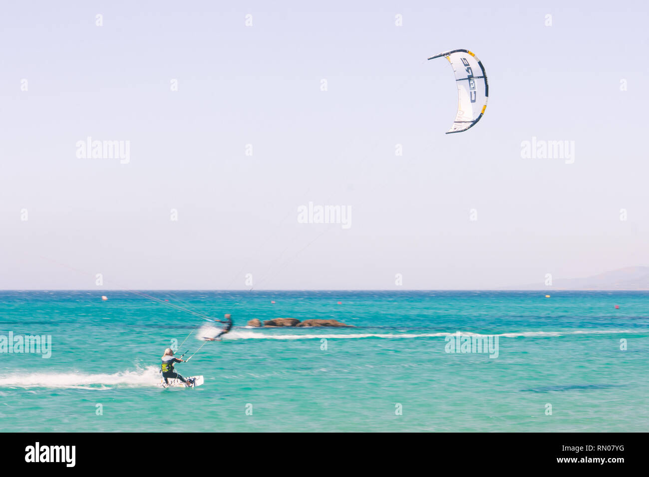 Immagine di un kite surfer di eseguire difficili acrobazie in venti alti. Extrme sport girato a Tarifa, Andalusia, Spagna Foto Stock