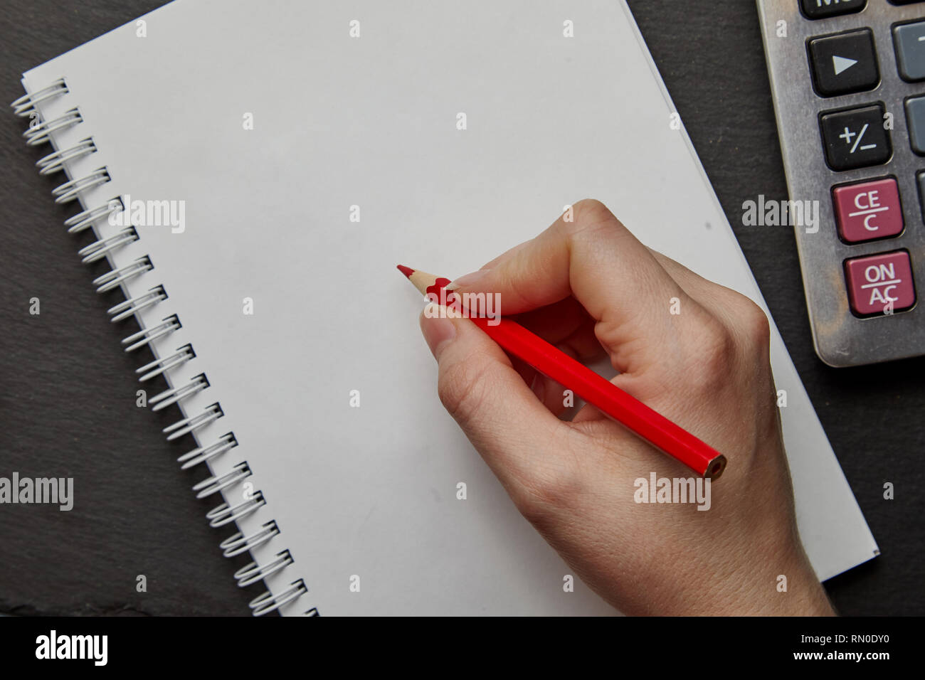 La scrittura a mano su notebook con matita in legno Foto Stock