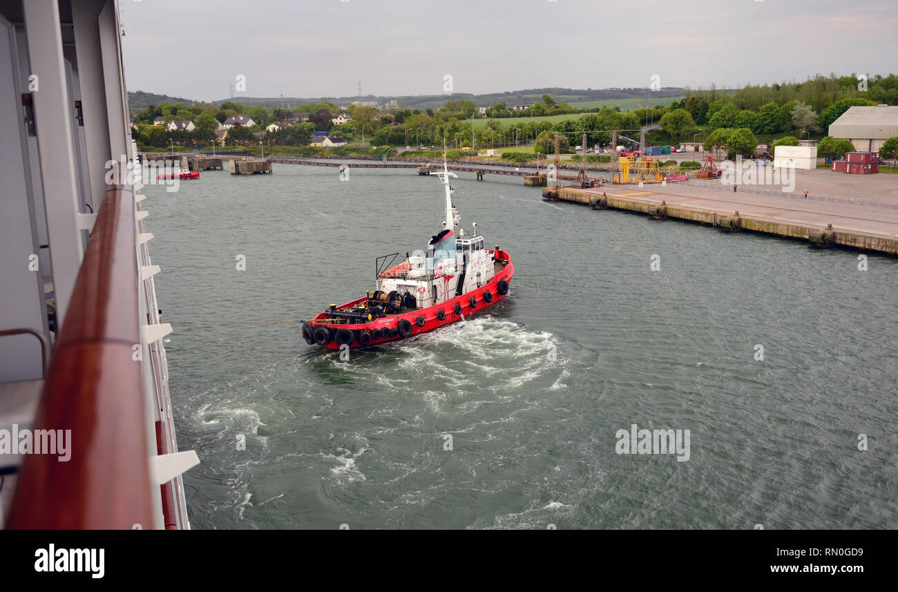 Rimorchiatore Breedbank guida di una nave da crociera nel suo Ormeggio al porto di Ringaskiddy, nella contea di Cork. Foto Stock