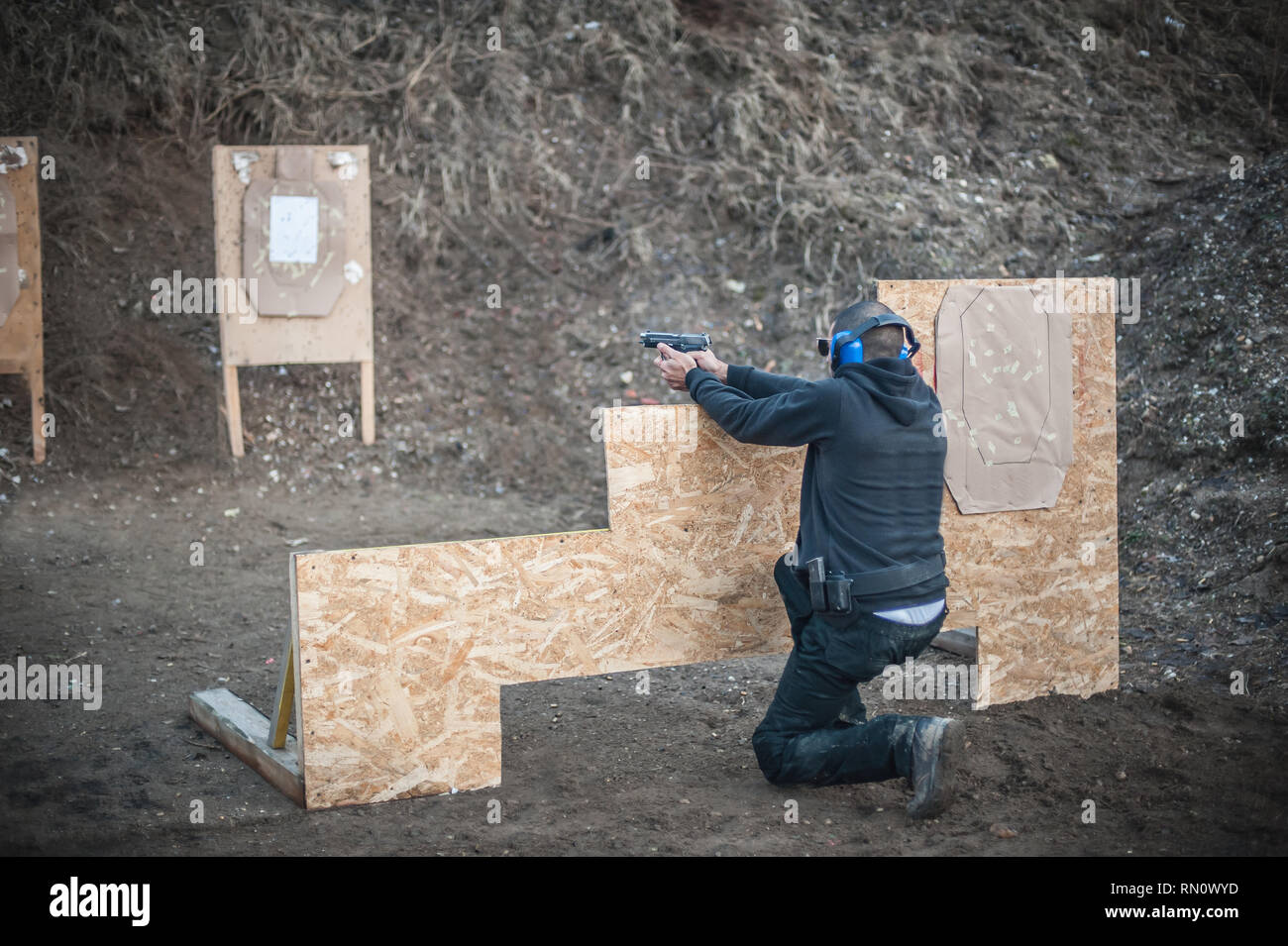 Advanced outdoor di tiro tattico su target intorno alla barriera e la parete. Arma da fuoco civili la formazione in materia di sicurezza sul poligono di tiro Foto Stock