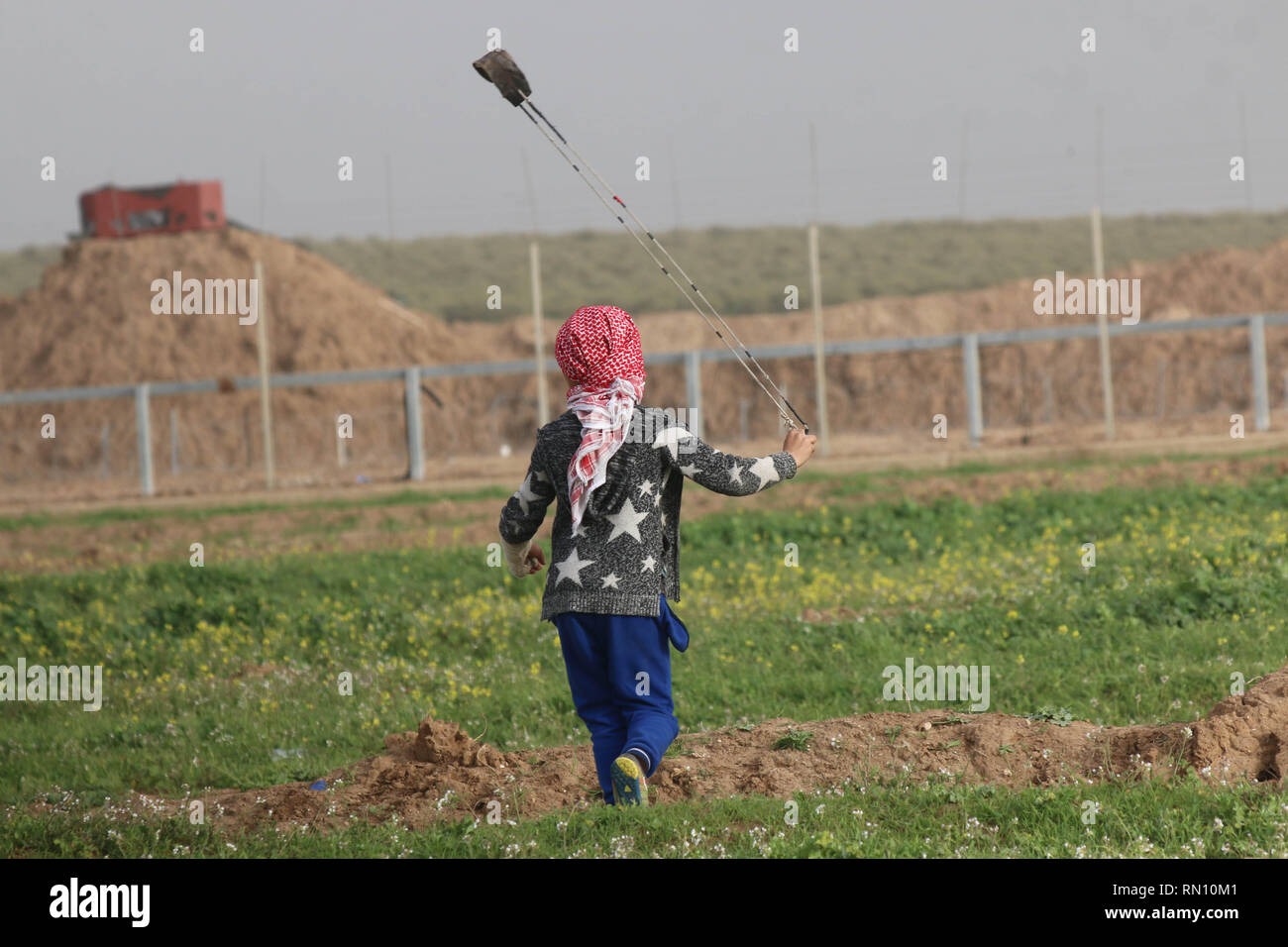 Bambino palestinese visto che lanciano pietre verso la forza israeliana durante gli scontri tra i cittadini palestinesi e le forze israeliane ad est di Gaza City mentre protestavano contro il riconoscimento di Gerusalemme come capitale di Israele da parte del Presidente USA Trump e rifiutato il blocco. Foto Stock