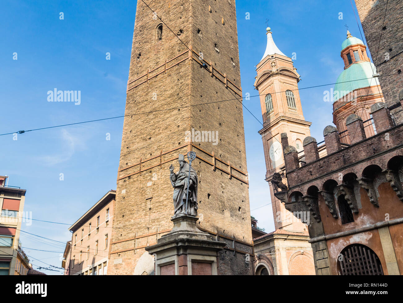 Statua del vescovo San Petronio, Torre della Garisenda e Chiesa Santi Bartolomeo e Gaetano a Bologna, Italia Foto Stock