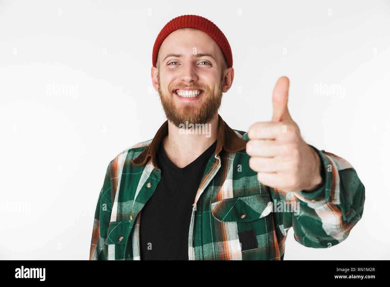 Ritratto di europeo uomo barbuto che indossa un cappello e plaid shirt che mostra un pollice alzato in piedi isolato su sfondo bianco Foto Stock