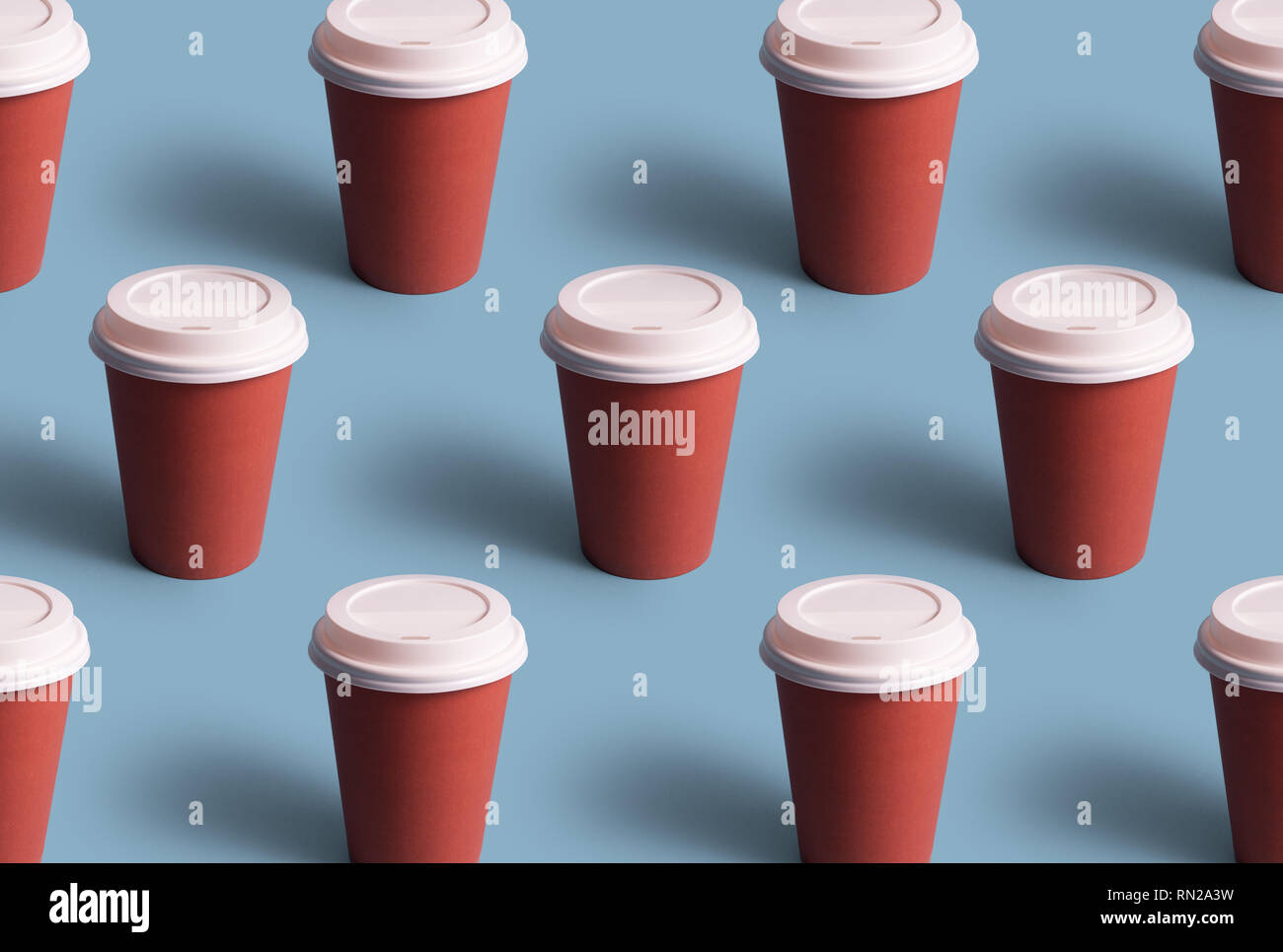 Monouso tazze di caffè organizzati in una riga su sfondo blu Foto Stock