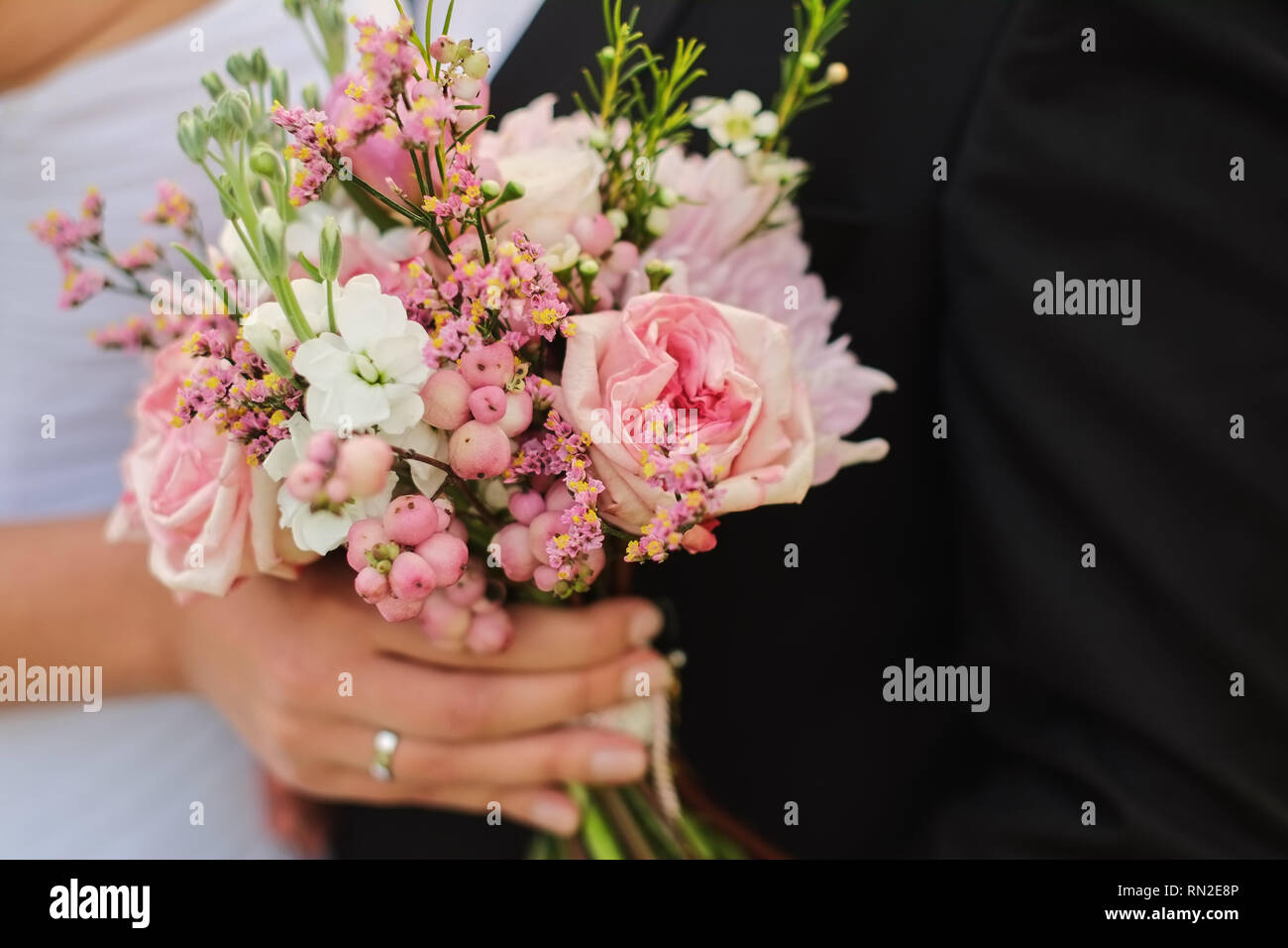 Sposa tiene un mazzo di nozze in mani, lo sposo abbraccia il suo Foto Stock