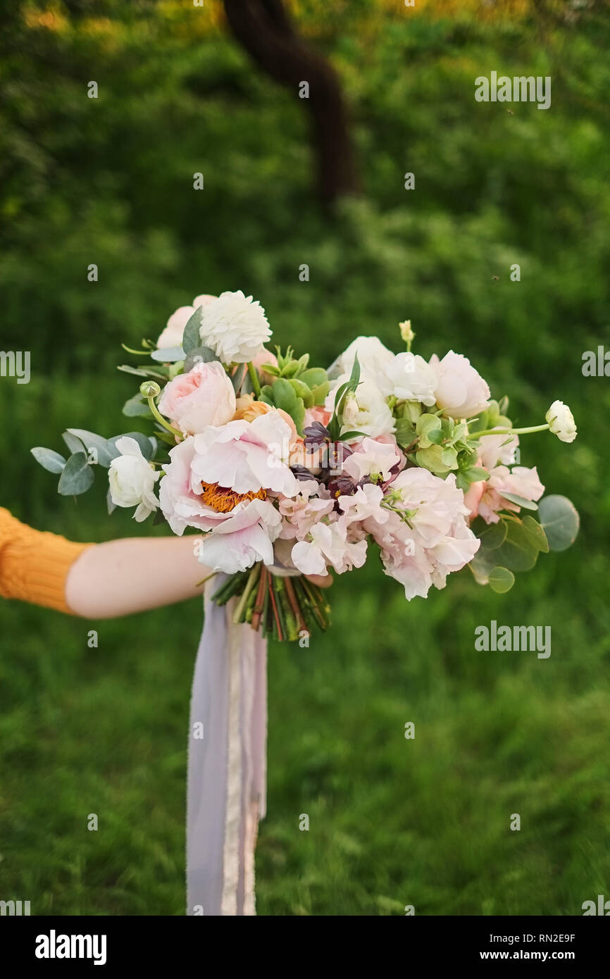 La sposa il bouquet. Fiore donna tiene in mano un bellissimo matrimonio bouquet di fiori per la sposa. Fine-art wedding Foto Stock