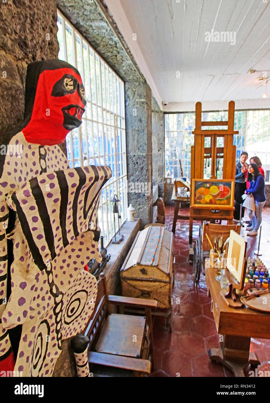 Frida Kahlo Museum, officina con cavalletto, sedia a rotelle, pittura forniture, e uno dei suoi cartapesta folk art sculture a sinistra. Foto Stock
